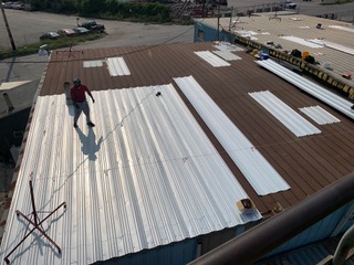 MidMass crew retrofitting a metal building roof